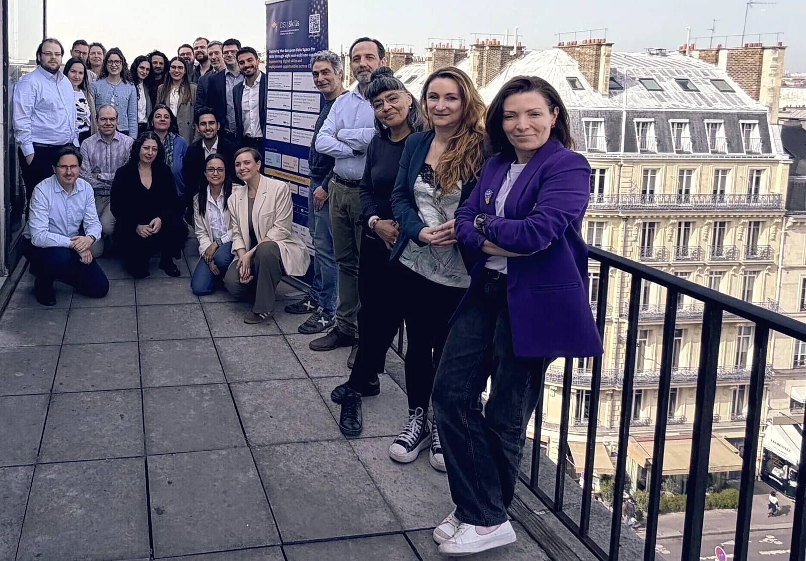 About thirty members of the DS4Skills consortium on a Paris terrace, around a project banner